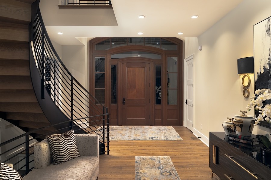 A home entryway with a wood floor and architectural ceiling lighting.