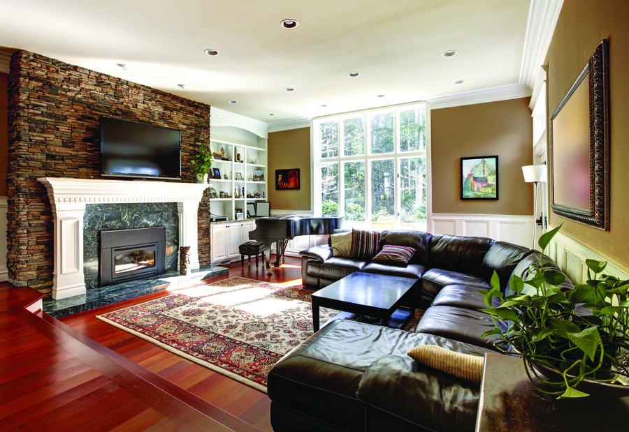 Image is of a modern living room with brown leather furniture.