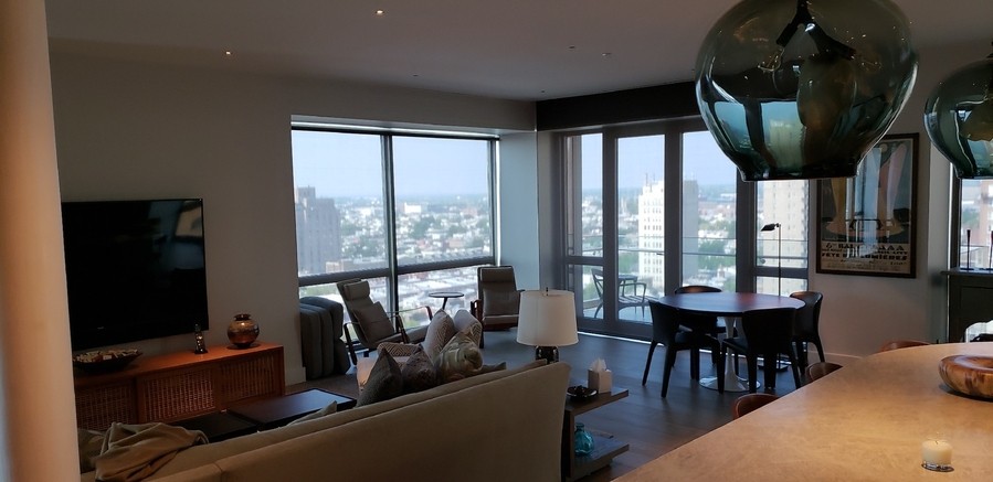 Lutron roller shades in a high-rise apartment overlooking a cityscape