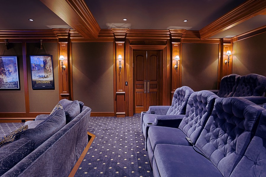 two rows of blue home theater seating in a luxury entertainment room